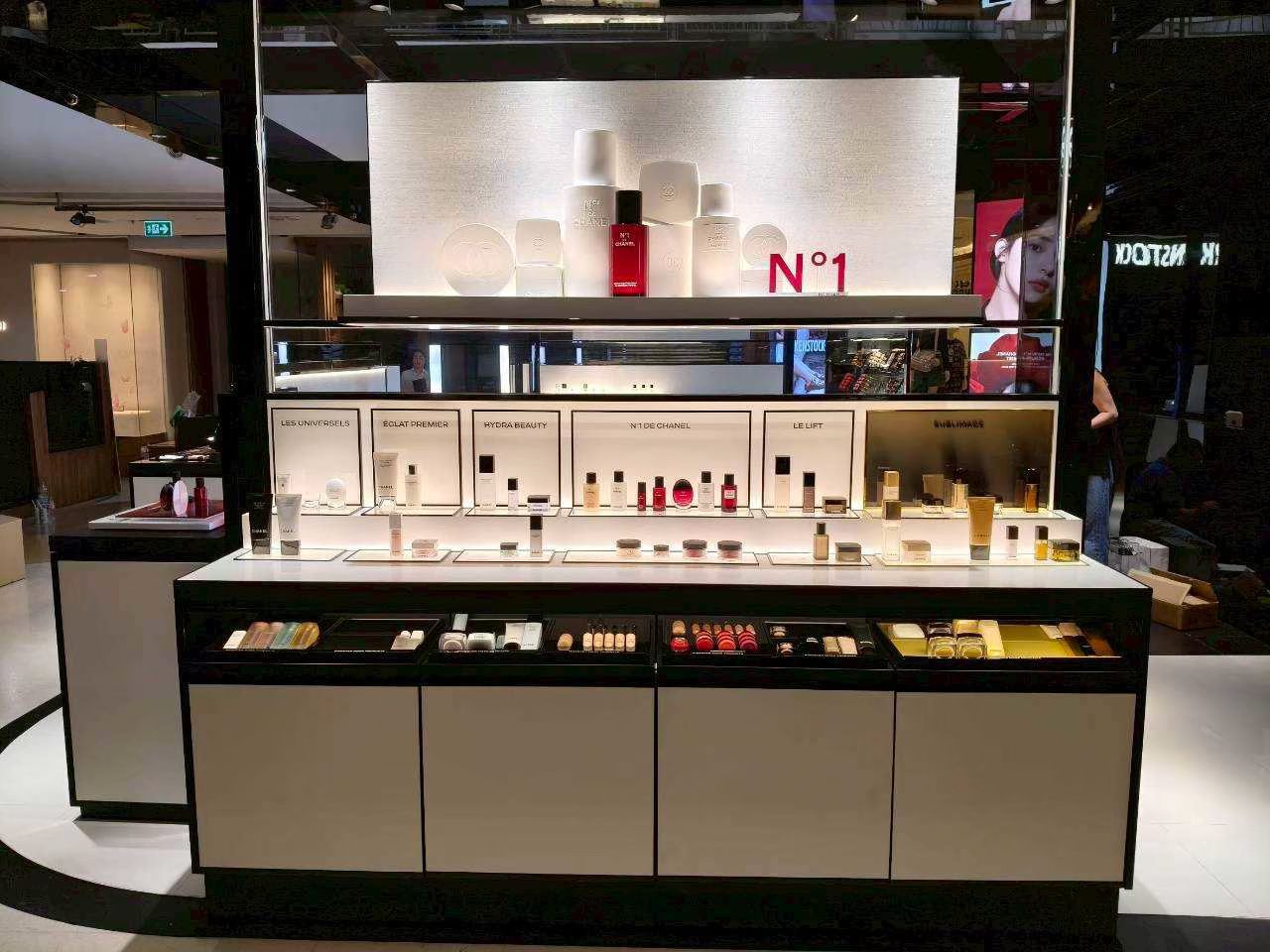 White N°1 de Chanel display counter with backlit shelving